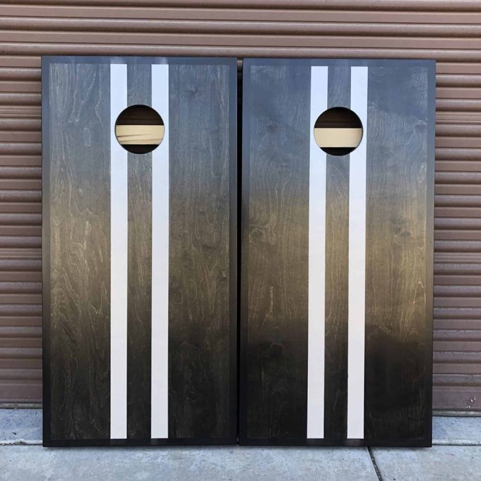 Onyx Stained Pinstripe cornhole board with garage background